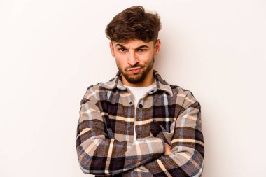 Beyaz arka planda izole edilmiş, hoşnutsuzca kaşlarını çatmış, kollarını kavuşturmuş genç bir İspanyol..