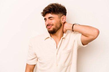 Genç İspanyol bir adam beyaz arka planda izole edilmiş, dirsek masajı yapıyor, kötü bir hareketin ardından acı çekiyor..