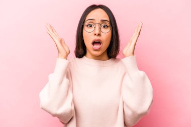 Pembe arka planda izole edilmiş genç İspanyol kadın şaşırdı ve şok oldu..