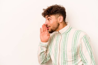 Beyaz arka planda izole edilmiş genç İspanyol bir adam gizli bir sıcak fren haberi veriyor ve yana bakıyor.