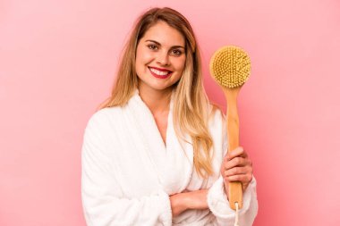 Kafkasyalı genç bir kadın pembe arka planda kendini izole edip gülüyor ve eğleniyor..