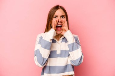 Pembe arka planda izole edilmiş beyaz bir kadın heyecanlı bir şekilde bağırıyor..