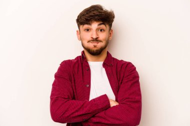 Beyaz arka planda izole edilmiş genç İspanyol adam yanakları patlatıyor, yorgun bir ifadesi var. Yüz ifadesi kavramı.