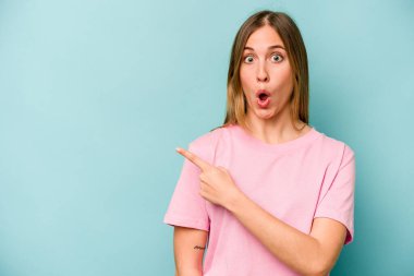 Mavi arka planda izole edilmiş genç beyaz kadın...