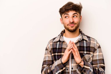 Latin kökenli genç bir adam beyaz arka planda izole edilmiş. Aklında bir plan kuruyor..