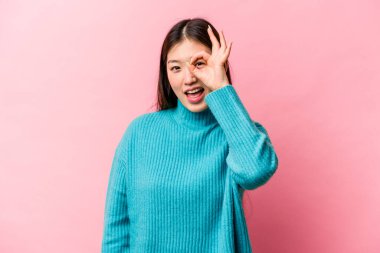 Pembe arka planda izole edilmiş genç bir Çinli kadın heyecanlı..