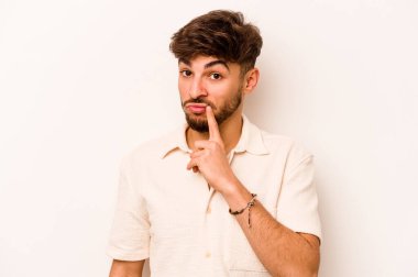 Latin kökenli genç bir adam beyaz arka planda izole edilmiş. Bir strateji planlıyor, bir iş yolu düşünüyor..