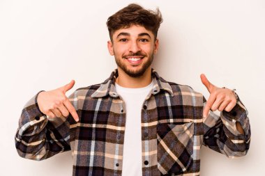 Beyaz arka planda izole edilmiş genç bir İspanyol. Parmakları aşağıda, olumlu hisler içinde..