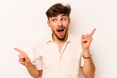 Beyaz arka planda izole edilmiş genç İspanyol adam farklı kopya alanlarını gösteriyor, birini seçiyor, parmaklarıyla gösteriyor..