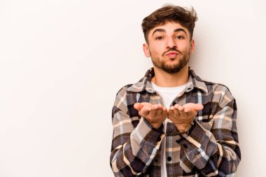 Beyaz arka planda izole edilmiş, dudakları kıvrılmış ve hava öpücüğü yollamak için avuç içi tutan İspanyol bir adam..