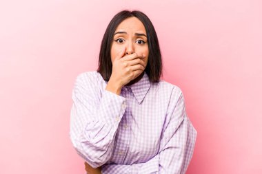 Genç İspanyol kadın pembe arka planda izole edilmiş korkmuş ve korkmuş..