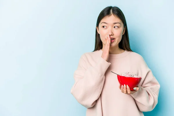 Jonge Aziatische Vrouw Met Een Kom Granen Geïsoleerd Blauwe Achtergrond — Stockfoto