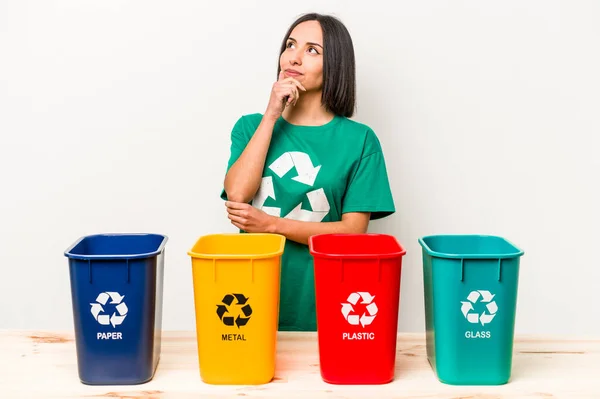 Young Hispanic Woman Recycling Isolated White Background Looking Sideways Doubtful — Stock Photo, Image