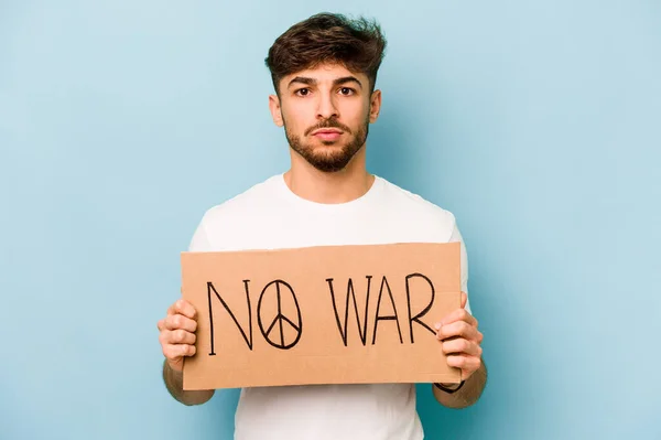 Young hispanic man holding no war placard isolated on white background