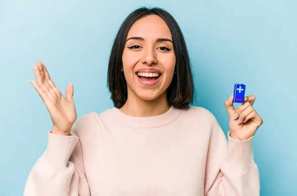 Junge Hispanische Frau Hält Batterien Isoliert Auf Blauem Hintergrund Und — Stockfoto