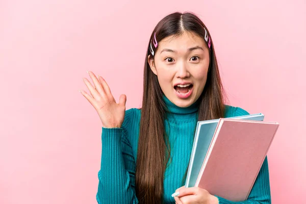 Молодая Азиатская Студентка Держит Книги Изолированы Розовом Фоне Получая Приятный — стоковое фото