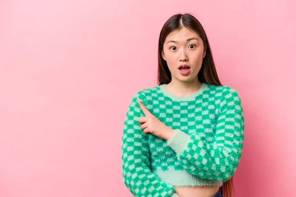 Joven Mujer China Aislada Sobre Fondo Rosa Apuntando Hacia Lado —  Fotos de Stock