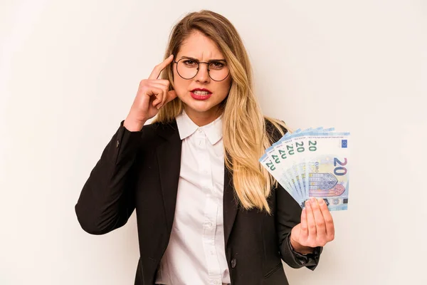 白地に孤立した紙幣を持つ若い実業家の白人女性は 額と失望のジェスチャーを示しています — ストック写真