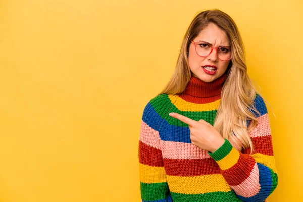 Jovem Caucasiana Isolada Sobre Fundo Amarelo Apontando Para Lado — Fotografia de Stock