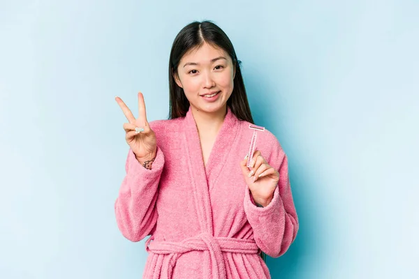 Junge Asiatische Frau Hält Rasierklinge Isoliert Auf Blauem Hintergrund Fröhlich — Stockfoto