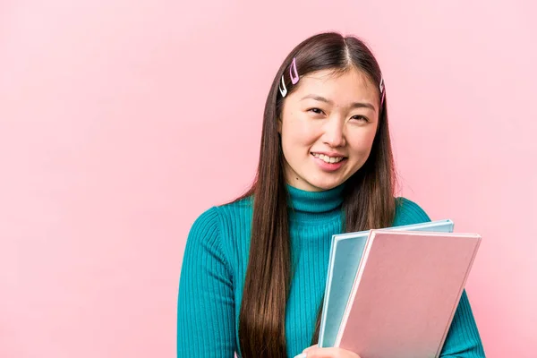 Asyalı Genç Bir Bayan Pembe Arka Planda Kitap Tutuyor Gülüyor — Stok fotoğraf