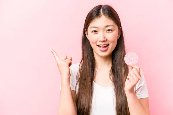 Joven Asiática Sosteniendo Esponja Facial Aislada Sobre Fondo Rosa Sonriendo — Foto de Stock