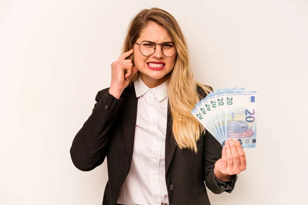 手で耳を覆う白い背景に孤立した紙幣を持つ若い実業家の白人女性 — ストック写真