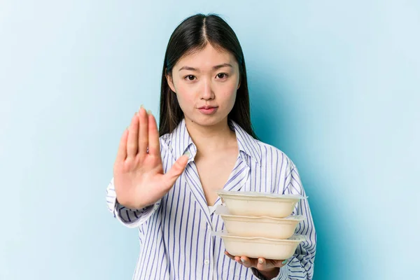Fiatal Ázsiai Gazdaság Tupperware Elszigetelt Kék Háttér Álló Kinyújtott Kézzel — Stock Fotó