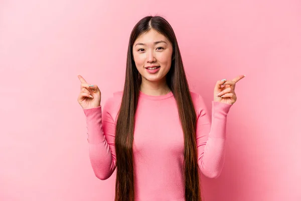 Jonge Chinese Vrouw Geïsoleerd Roze Achtergrond Wijzend Naar Verschillende Kopieerruimtes — Stockfoto