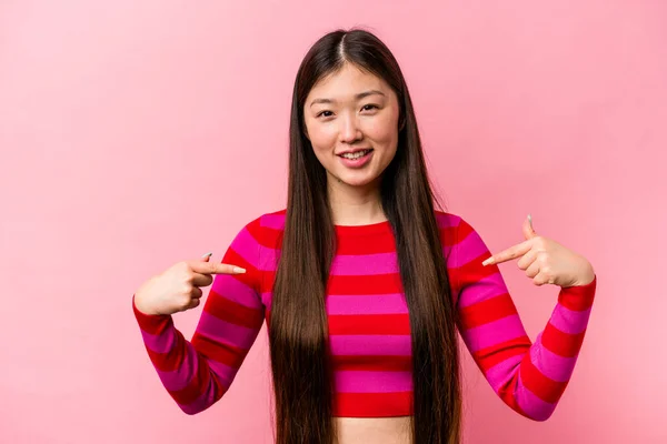 Joven Mujer China Aislada Sobre Fondo Rosa Apunta Hacia Abajo —  Fotos de Stock