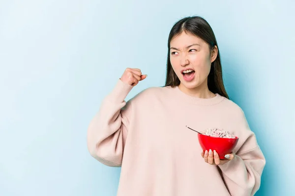 Jonge Aziatische Vrouw Met Een Kom Van Granen Geïsoleerd Blauwe — Stockfoto