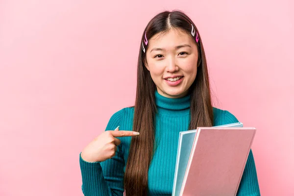 Νεαρή Ασιάτισσα Φοιτήτρια Που Κρατάει Βιβλία Απομονωμένα Ροζ Φόντο Δείχνοντας — Φωτογραφία Αρχείου