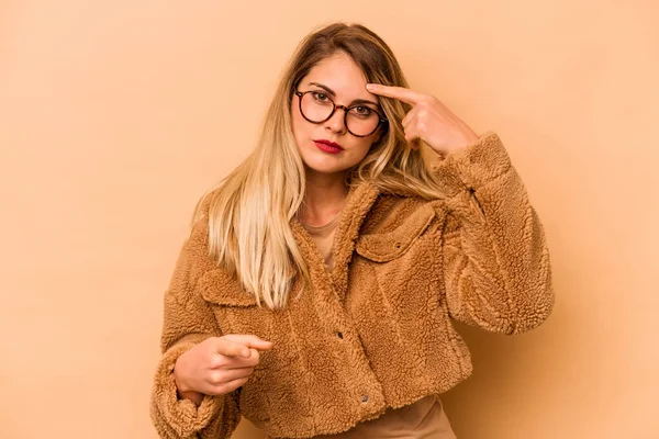 Mulher Branca Jovem Isolado Fundo Bege Apontando Templo Com Dedo — Fotografia de Stock