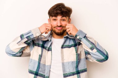 Latin kökenli genç bir adam beyaz arka planda iki seçenek arasında kuşkulanıyor..