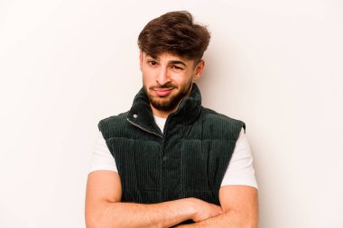 Beyaz arka planda izole edilmiş genç İspanyol adam alaycı bir ifadeyle kameraya bakıyor..