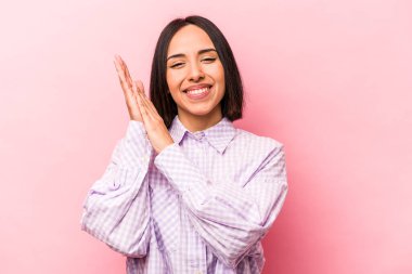 Pembe arka planda izole edilmiş genç İspanyol kadın enerjik ve rahat hissediyor, ellerini ovuşturuyor..