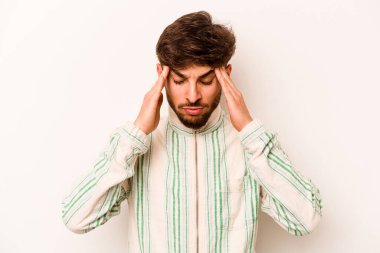 Beyaz arka planda izole edilmiş genç İspanyol adam tapınaklara dokunuyor ve baş ağrısı çekiyor..
