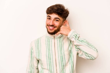 Beyaz arka planda izole edilmiş genç bir İspanyol, parmakları olan bir cep telefonu hareketi gösteriyor..