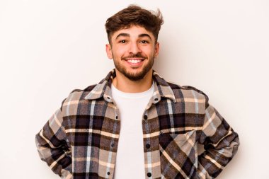 Beyaz arka planda izole edilmiş genç İspanyol adam mutlu, güler yüzlü ve neşeli.