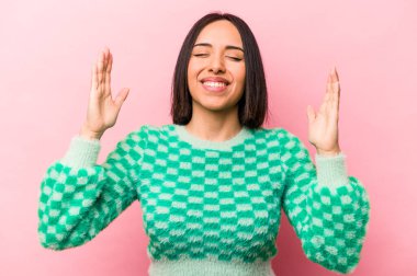 Genç İspanyol kadın pembe arka planda izole edilmiş neşeli bir şekilde gülüyor. Mutluluk kavramı.