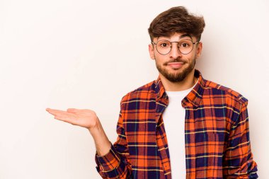 Beyaz arka planda izole edilmiş genç İspanyol bir adam bir avuç içinde fotokopi alanı ve belinde bir el daha gösteriyor..