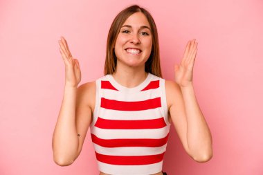 Pembe arka planda soyutlanmış beyaz bir kadın yüksek sesle gülüyor ve elini göğsüne koyuyor..