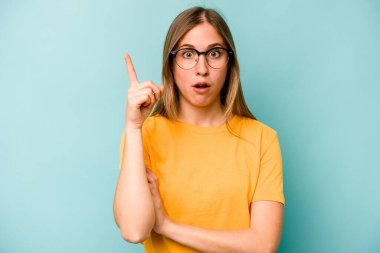 Kafkasyalı genç bir kadın mavi arka planda izole edilmiş. Harika bir fikri var, yaratıcılık kavramı..