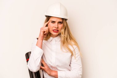 Miğferli ve elinde beyaz arka planda izole edilmiş planlar tutan genç mimar kadın işaret parmağıyla yaptığı hayal kırıklığı jestini gösteriyor..