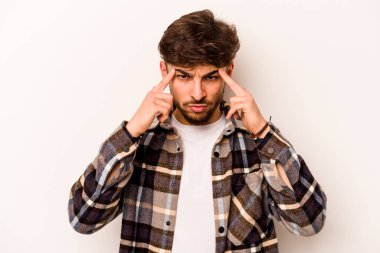 Beyaz arka planda izole edilmiş genç İspanyol bir adam bir göreve odaklanmış, işaret parmaklarını işaret ediyor..