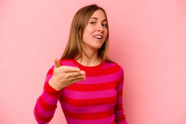 Pembe arka planda izole edilmiş beyaz bir kadın. Kameraya elini uzatıp selam veriyor..