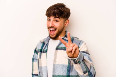 Beyaz arka planda izole edilmiş genç İspanyol adam iki numarayı parmaklarıyla gösteriyor..