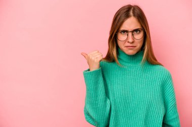 Pembe arka planda izole edilmiş beyaz bir kadın işaret parmağıyla bir fotokopi alanını işaret ederek şok geçirdi..