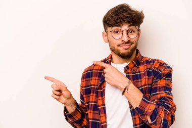 Beyaz arka planda izole edilmiş genç İspanyol adam işaret parmağıyla fotokopi alanını işaret ederek şok oldu..