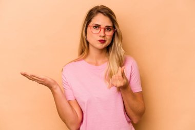 Beyazlı genç bir kadın bej arka planda izole edilmiş. Parası olmadığını gösteriyor..